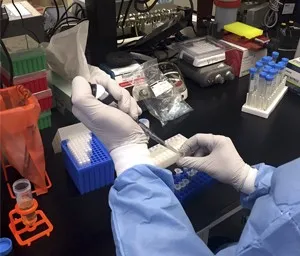 a person in a lab coat working on a device